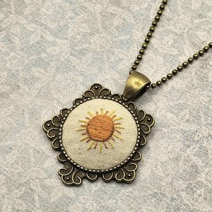 Vintage style sunshine necklace in a brass pendant setting.