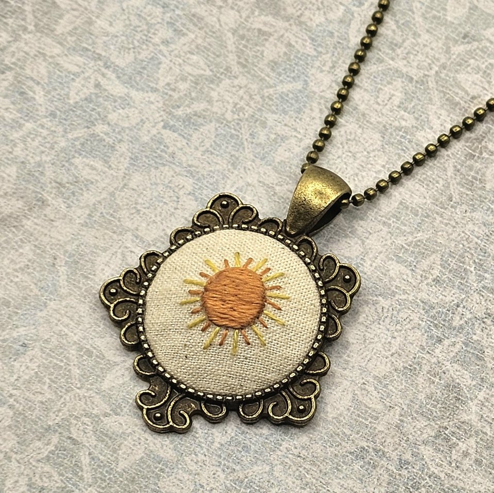 Vintage style sunshine necklace in a brass pendant setting.